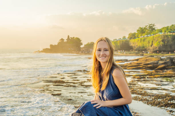 giovane turista donna sullo sfondo di tanah lot - tempio nell'oceano. bali - travel destinations bali tanah lot temple foto e immagini stock