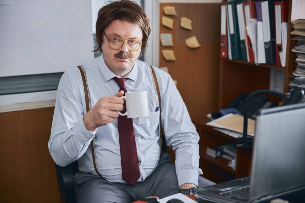 istock Middle-aged office functionary sitting with cup of tea at a laptop 1227036256