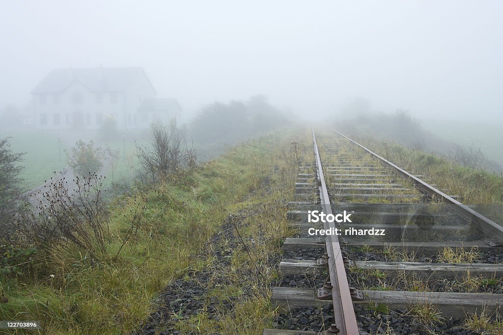 old railroad and house vanishing in fog  Autumn Stock Photo