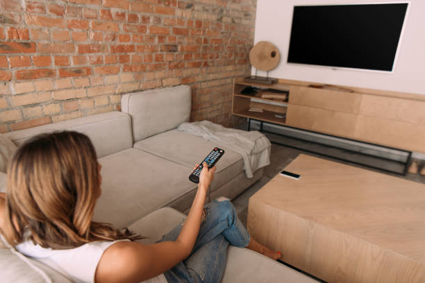 istock girl holding remote controller and watching tv with blank screen during self isolation, selective focus 1227040129