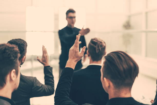 istock rear view. employees ask questions at a business briefing 1227044838