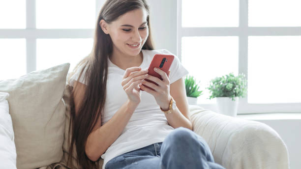 istock young woman with a smartphone sitting on a comfortable sofa 1227046450