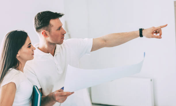 istock woman designer and a young man standing in an empty apartment 1227046557