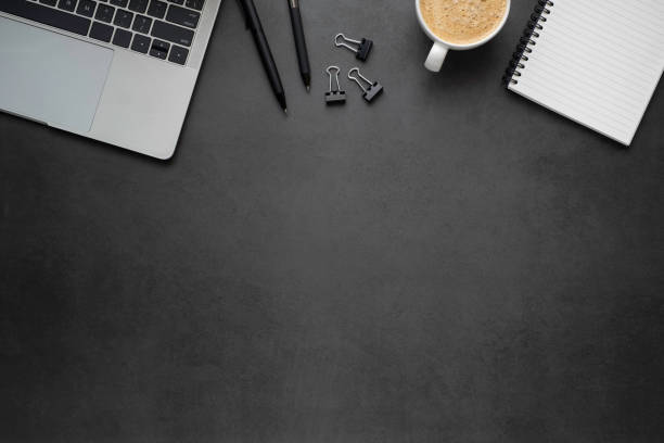 istock Workplace office with dark grey desk. Top view from above of Laptop, Empty open notebook with pens and coffee. Flat lay, Business-finance or education concept with copy space. 1227053616