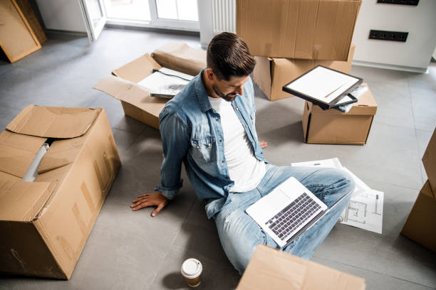 istock Young man with notebook and coffee in new flat 1227054322