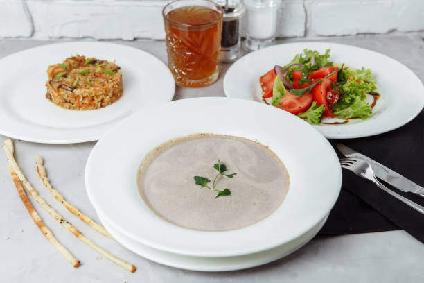 istock three-course set on a table in a restaurant, cafe menu. Business lunch from a plate with mushroom cream soup, with chicken and egg, a salad of fresh vegetables and pilaf 1227054615