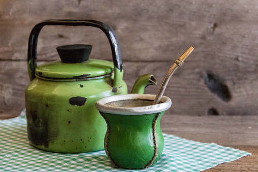 mate and kettle, traditional Argentine yerba mate infusion, on rustic wooden background