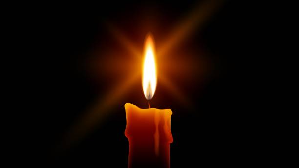 istock Candle flame burning in the dark with a stars bursts lens flare 1227056576