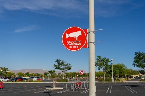 Apple Valley, CA / USA – May 24, 2020: A red circle sign that reads, Security Camera In Use, in a parking lot for the Target retail store located in Apple Valley, California.
