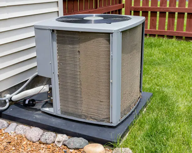 Photo of Dirty air conditioning unit before and after cleaning. Condensor coil full of dirt and grass debris. Concept of home air conditioning repair, service, cleaning and maintenance