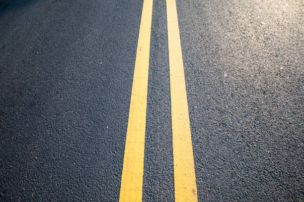 istock Closeup yellow dividing line on asphalt road 1227063121
