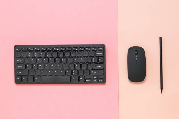 istock Black pencil, black mouse and keyboard on a two-color background. 1227064043