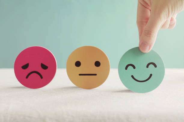 Hand choosing green happy smiley face paper cut, product, user, service feedback rating and customer reveiw, experience, satisfaction survey, psychology mental health test concept Hand choosing green happy smiley face paper cut, product, user, service feedback rating and customer reveiw, experience, satisfaction survey, psychology mental health test concept mental health photos stock pictures, royalty-free photos & images