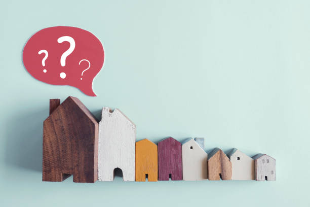 wooden houses with question marks, housing crisis, confused decision, insecure investment, choosing right property concept - ansiedade financeira imagens e fotografias de stock