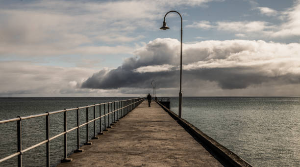 istock Lone Man Walking Away Pier 1227065166