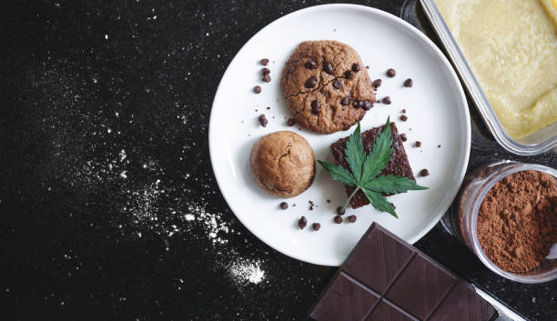 postres al horno galleta, brownie y bun infundidos con cannabis medicinal, con hoja de marihuana e ingredientes - chocolate chip cookie bakery chocolate homemade fotografías e imágenes de stock