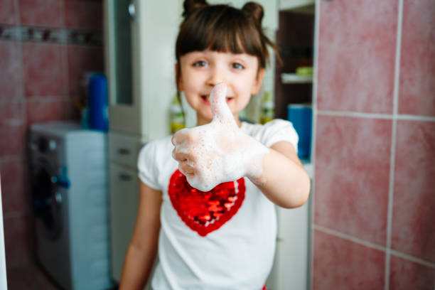 Little girl washing hands with water and soap in bathroom Little girl washing hands with water and soap in bathroom daycare cleaning stock pictures, royalty-free photos & images