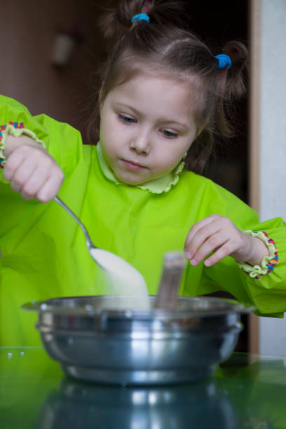 istock Five year old girl cooks cottage cheese casserole 1227072895