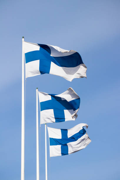 istock Three finnish national flags on the wind against the blue sky 1227077525