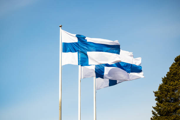 istock Three finnish national flags on the wind against the blue sky 1227077542