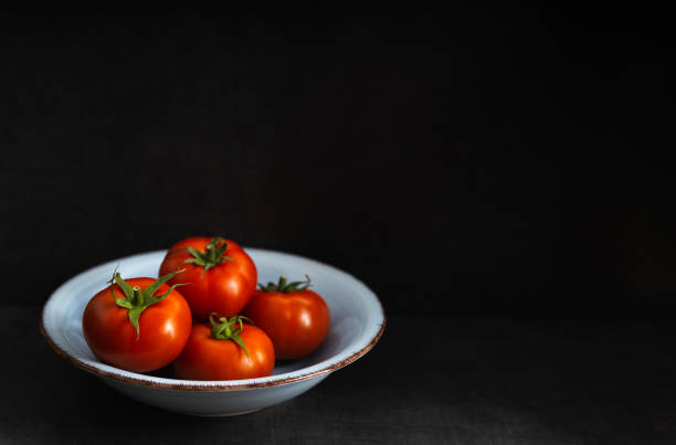 istock Fresh harvested tomato on a dark background 1227077552