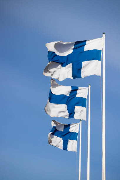 istock Three finnish national flags on the wind against the blue sky 1227077595