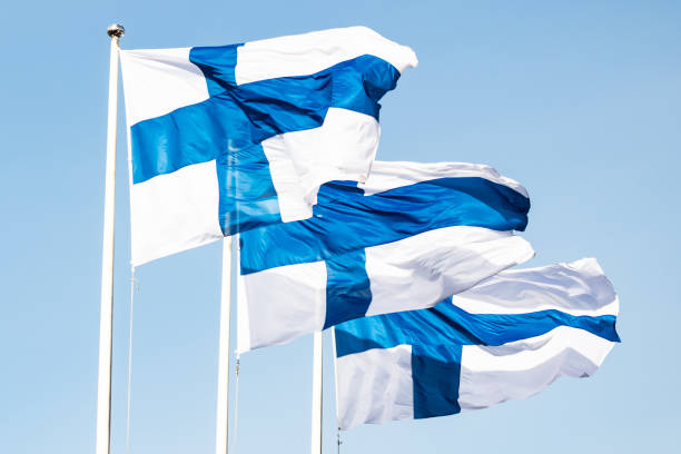istock Three finnish national flags on the wind against the blue sky 1227077603