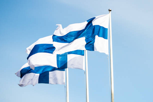 istock Three finnish national flags on the wind against the blue sky 1227077620