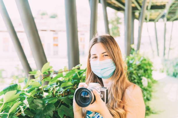 istock young woman taking a photo with an analog camera and a blurred background. 1227079418