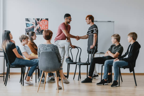 Reconciliation between friends Reconciliation between two friends on a group psychotherapy theater class stock pictures, royalty-free photos & images
