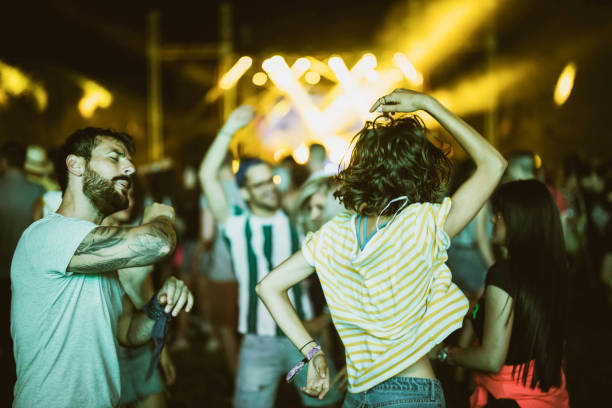 couples insouciants s’amusant tout en dansant sur le festival de musique la nuit. - crowd popular music concert music festival people photos et images de collection