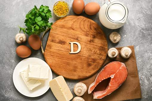 Empty cutting board and frame of varied food rich in vitamin D. Healthy eating concept. Top view, flat lay