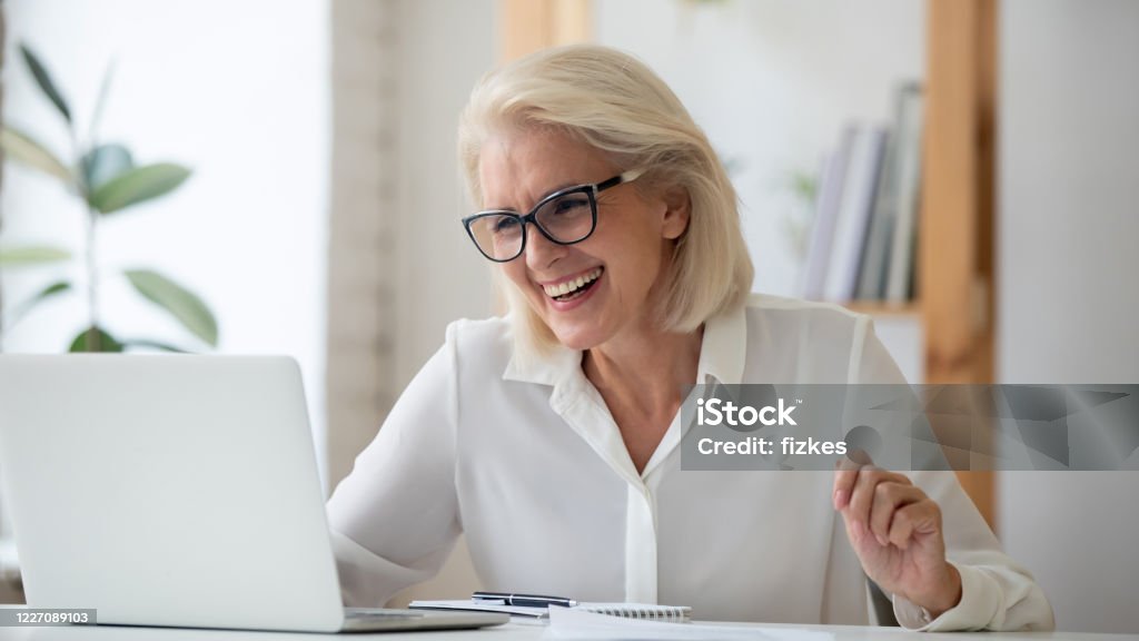 Dolblije senior vrouw krijgt aangename e-mail op laptop - Royalty-free E-mail Stockfoto