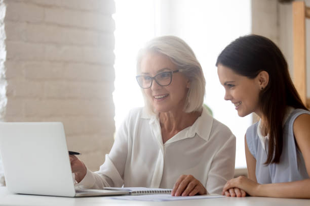 istock Smiling female colleagues discuss project on laptop 1227089133