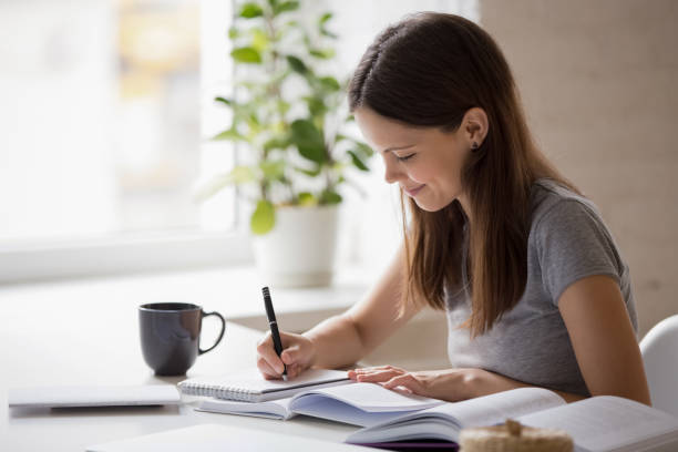 istock Smiling millennial girl studying at home making notes 1227089173