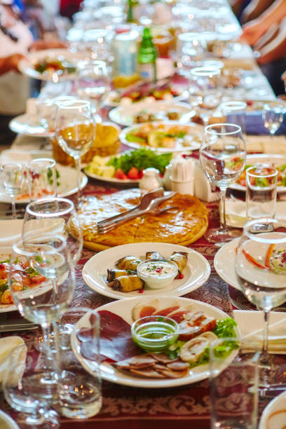 istock Long Banquet table. Drinks and snacks on the table. People are sitting at the table. Concept of joint celebrations 1227089452