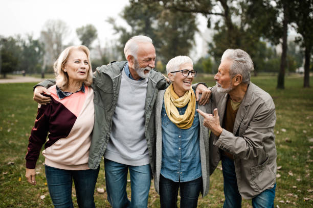 istock Happy seniors talking while walking embraced in nature. 1227089563