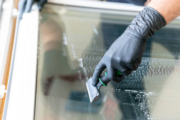 istock close up of a professional cleaneer using a diamond blade scraper to clean a window 1227089588