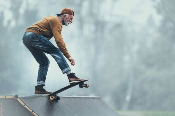 公園のランプで幸せなシニアマンスケートボード。 - skateboard ストックフォトと画像