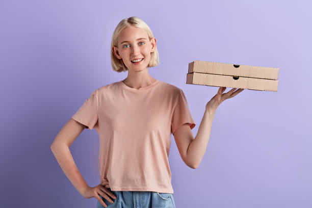istock cheerful smiling woman holding pizza boxes 1227090364