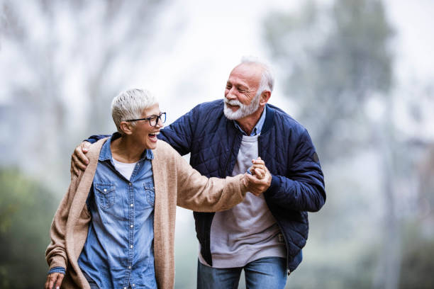 公園で楽しんで陽気なシニアカップル。 - senior adult fun autumn senior couple ストックフォトと画像