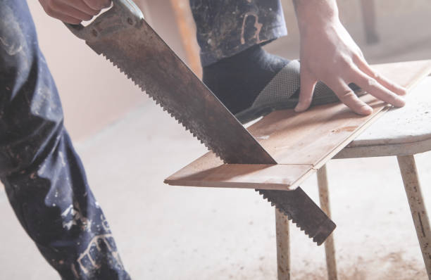 istock Carpenter hand with saw cutting board. 1227090714