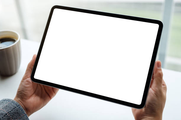 istock a woman holding black tablet pc with blank white screen with coffee cup on the table 1227091762