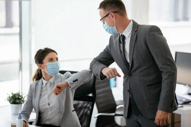 Photo of Businessman and businesswoman with medical mask in office.