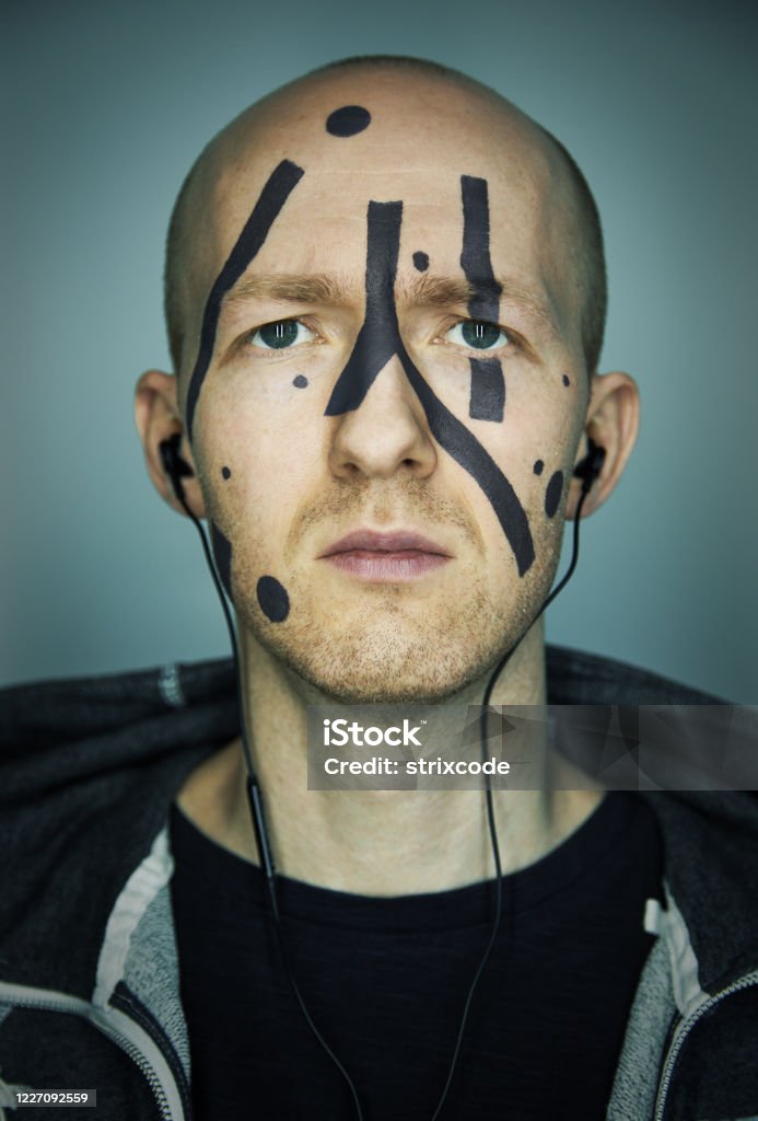 Close up portrait of man hiding his face from camera recognition with special camouflage makeup. Digital privacy in big city concept image. Achievement Stock Photo