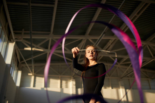 istock Young gymnast girl training in dark studio 1227093148