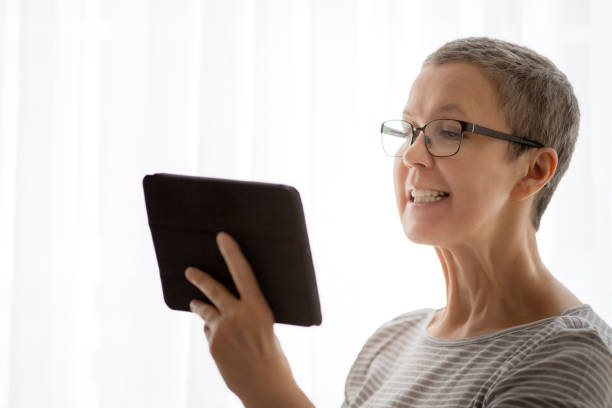 istock Mature woman communicates in a video conference using a tablet 1227093943