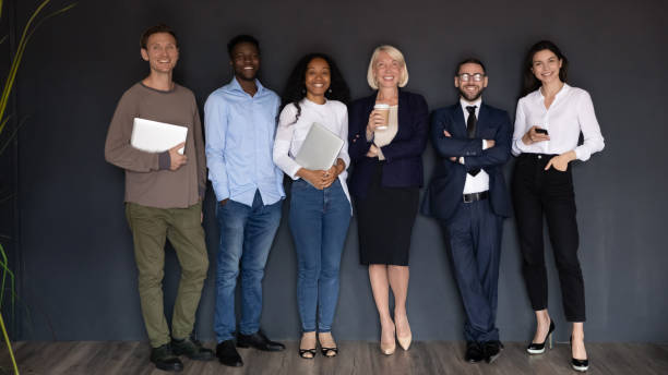 istock Smiling diverse business people standing in row on black background 1227094262