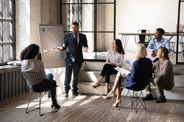 istock Confident businessman mentor presenting statistics on flip chart at meeting 1227094265