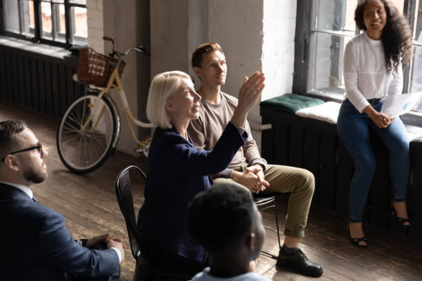 istock Middle aged businesswoman raising hand, asking question at briefing 1227094276